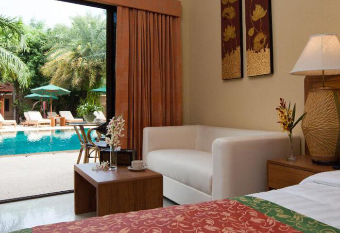 Baan Souy Resort, gay hotel Pattaya. Adults only room view of pool, lounge chairs, umbrellas. Best gay accommodations in Thailand.