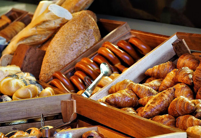 Hotel Kings Court's best breakfast: A wooden display of fresh bread, rolls, and croissants. A great start for gay travelers in Prague's Old Town.