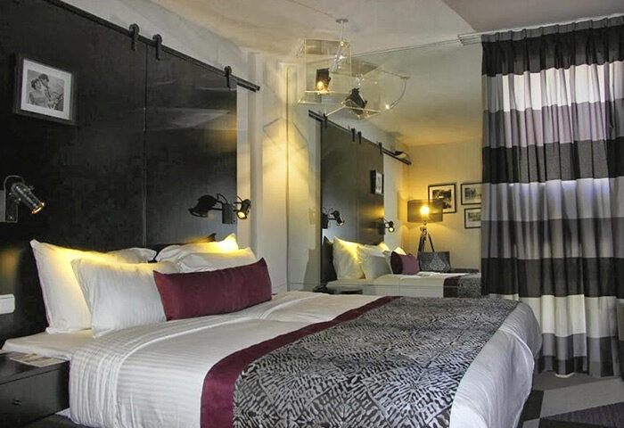 Cinema Hotel, Atlas Boutique Hotel, Tel Aviv. Gay couples' honeymoon suite. Modern design: striped curtain, black headboard, unique lighting.