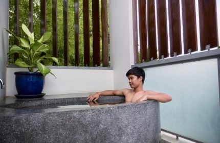 Gay man relaxing in a stone bathtub at Rambutan Resort, Phnom Penh. Best gay hotel and hangout in Phnom Penh for gay travelers.