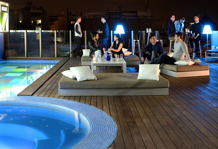 Axel Hotel Barcelona rooftop pool and bar at night. Gay adults only hotel, perfect for gay men to meet other gay men in Barcelona.