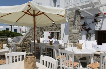 Elena Hotel, Mykonos. Outdoor dining area at the best gay hotel in Mykonos Town, a gayborhood to meet other gay travellers. Tables and chairs.