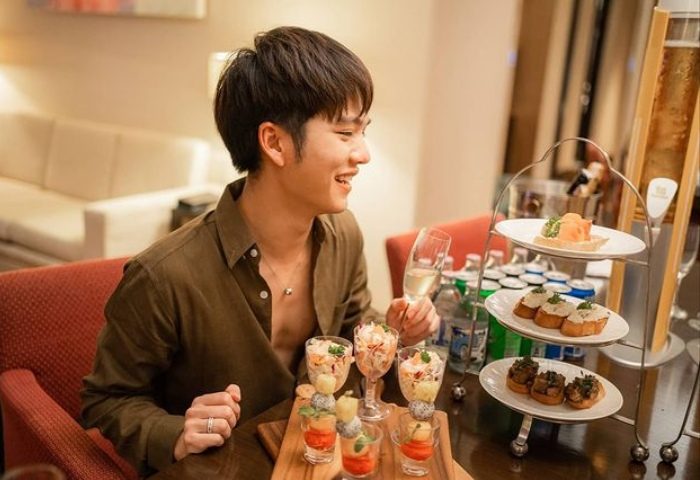 Gay traveler enjoying snacks at Sathorn Vista, Bangkok - Marriott Executive Apartments. Best gay hotels near Silom gay bars.
