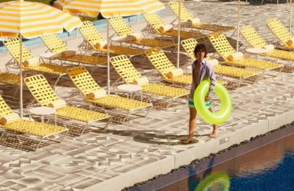 The Standard, Hua Hin: A man with a floatie at the gay-friendly hotel pool. Yellow striped umbrellas and lounge chairs line the pool at this beach resort.
