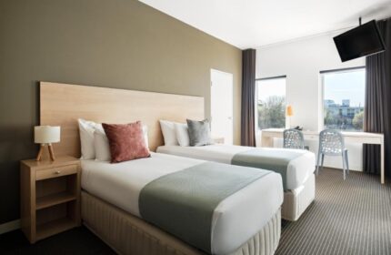 Saint Kilda Beach Hotel room. Twin beds, desk, and TV. One of the best gay hotels in Melbourne near gay saunas. Comfy stay guaranteed.