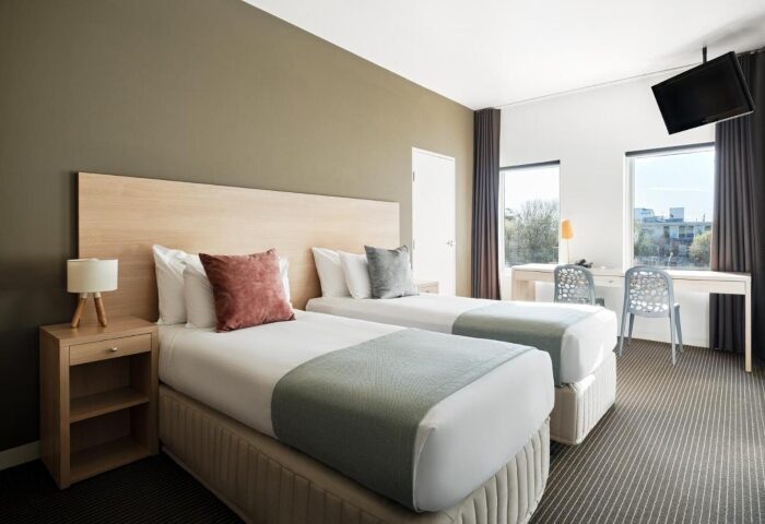 Saint Kilda Beach Hotel room. Twin beds, desk, and TV. One of the best gay hotels in Melbourne near gay saunas. Comfy stay guaranteed.