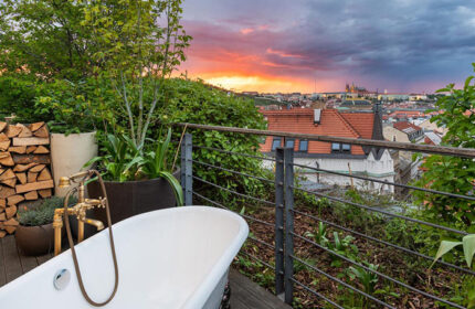 Mosaic House Design Hotel's private balcony with bathtub. Best gay hotels Prague Old Town view at sunset. Gay travel luxury.