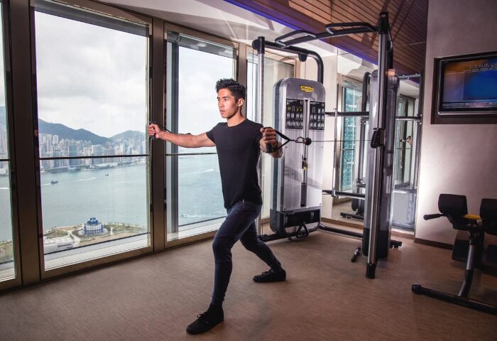 W Hong Kong gym with a gay man working out. Victoria Harbour view. Best gay hotels. Travel advice.