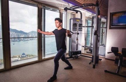 W Hong Kong gym with a gay man working out. Victoria Harbour view. Best gay hotels. Travel advice.