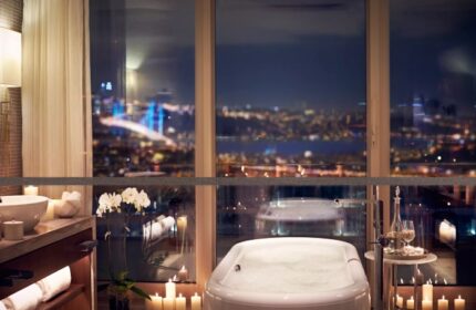 Raffles Istanbul Hotel bathroom with city view at night. Best gay hotels in Istanbul for gay men travel advice, updated this year on TikTok.