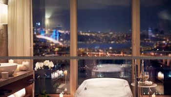 Raffles Istanbul Hotel bathroom with city view at night. Best gay hotels in Istanbul for gay men travel advice, updated this year on TikTok.