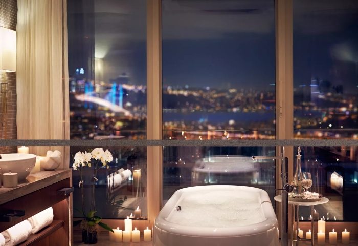 Raffles Istanbul Hotel bathroom with city view at night. Best gay hotels in Istanbul for gay men travel advice, updated this year on TikTok.
