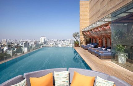 Hotel Des Arts Saigon rooftop pool, a best gay hotel. Infinity pool overlooking the city. Loungers and seating area. Gay travel.