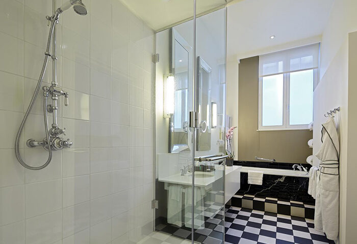 Bathroom at Sofitel St James London Hotel, best gay location for gay travelers. Features shower, tub, and black & white checkered floor.
