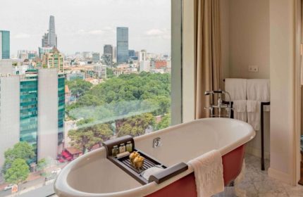 Luxury bathroom at Hôtel des Arts Saigon - MGallery Collection. Bathtub with city view. Best gay hotel in Ho Chi Minh City.