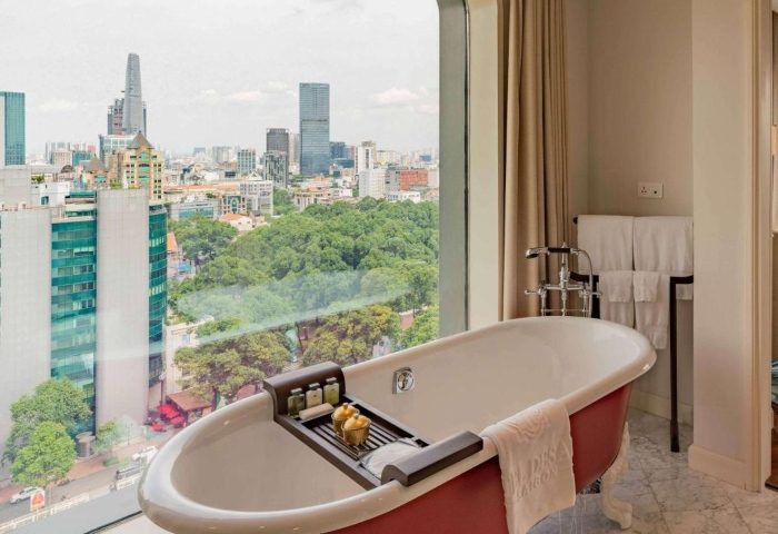 Luxury bathroom at Hôtel des Arts Saigon - MGallery Collection. Bathtub with city view. Best gay hotel in Ho Chi Minh City.