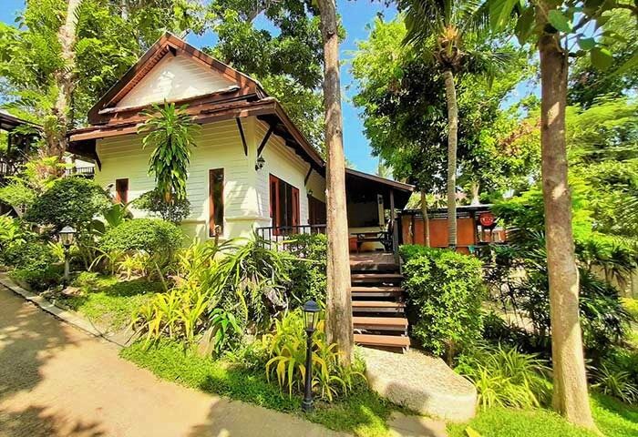 Alpha Gay Resort & Spa, Koh Samui. Best gay men-only hotel. Lush greenery surrounds a cozy bungalow. Perfect for gay travel.