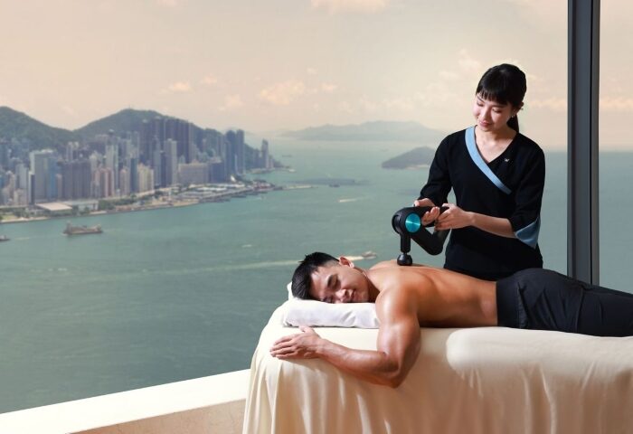 Gay wellness at W Hong Kong. Man receiving massage with Victoria Harbour view. Best gay hotel in Hong Kong city center.