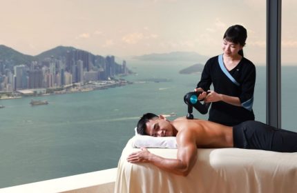 Gay wellness at W Hong Kong. Man receiving massage with Victoria Harbour view. Best gay hotel in Hong Kong city center.
