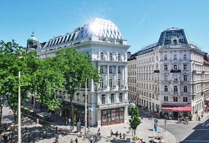 Hotel Motto, a high-end gay-friendly hotel in Vienna city center. View of the hotel's ornate facade and bustling street scene.