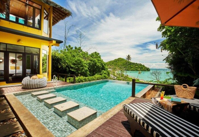 SAii Phi Phi Island Village: Beachfront pool at gay-friendly honeymoon hotel. Tropical view, lounge chairs, and turquoise water. Perfect for couples.