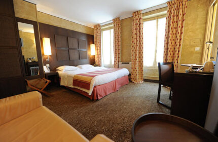 Hotel Du Vieux Saule, Paris honeymoon hotel room for gay couples. Elegant bedroom with double bed, desk, and seating area. Best honeymoon ideas.