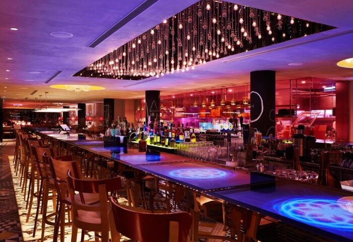 M Social Singapore's best hotel bar. Gay-friendly spot with unique lighting, bottles, and glasses. A vibrant, welcoming atmosphere.