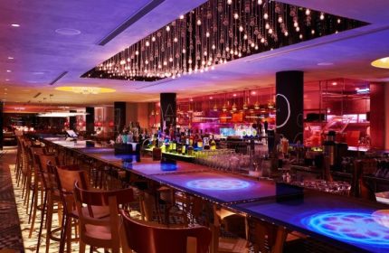 M Social Singapore's best hotel bar. Gay-friendly spot with unique lighting, bottles, and glasses. A vibrant, welcoming atmosphere.