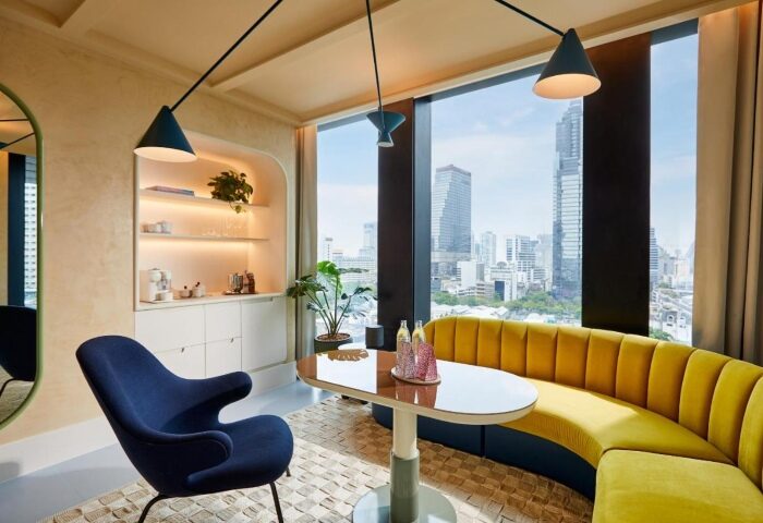 Breakfast at The Standard, Bangkok Mahanakhon, a gay-friendly hotel. View of the city from a yellow booth. Modern design, stylish hotel.