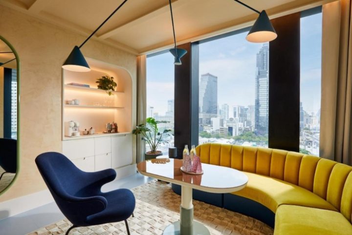 Breakfast at The Standard, Bangkok Mahanakhon, a gay-friendly hotel. View of the city from a yellow booth. Modern design, stylish hotel.