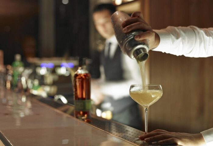 Hotel Proverbs Taipei cocktail bar. Bartender pouring drink into glass. Best hotel near Taipei gay nightlife for gay men travel.
