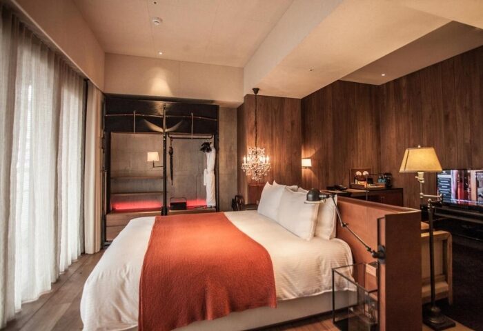 Hotel Proverbs Taipei bedroom. Best Instagram-perfect gay hotel. Features wood paneling, chandelier, and open closet. Gay travel in Taipei.
