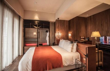 Hotel Proverbs Taipei bedroom. Best Instagram-perfect gay hotel. Features wood paneling, chandelier, and open closet. Gay travel in Taipei.