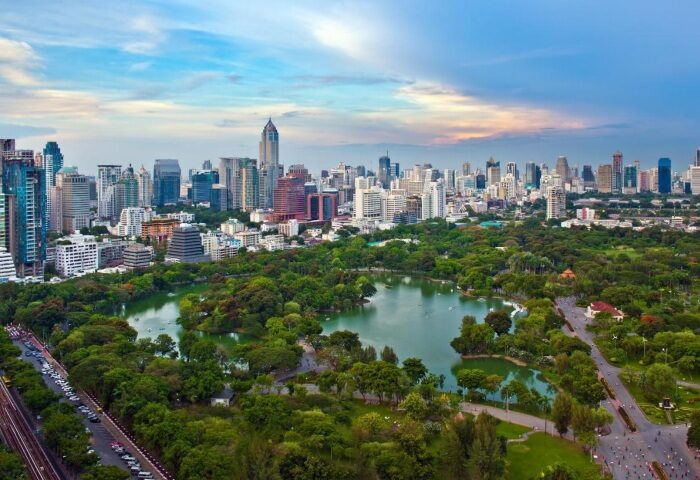 Bangkok's Lumpini Park view from Crowne Plaza Hotel, a luxury gay-friendly hotel near gay bars. Skyline with lake and lush greenery.