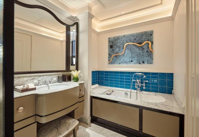 Bathroom at Great Scotland Yard Hotel, a luxury gay-friendly hotel near Soho, London. Features a tub, sink, mirror, and modern decor.
