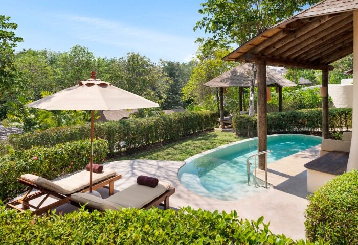 The Naka Island Phuket luxury pool villa. Gay hotel with outdoor pool, sun loungers, and lush greenery. Perfect for gay travel.