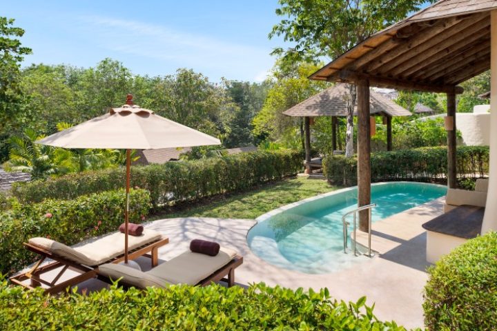 The Naka Island Phuket luxury pool villa. Gay hotel with outdoor pool, sun loungers, and lush greenery. Perfect for gay travel.