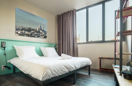 Les Piaules hostel room in Paris. Double bed, Sacré-Cœur art. Best party gay hostel city center for gay men travelers.
