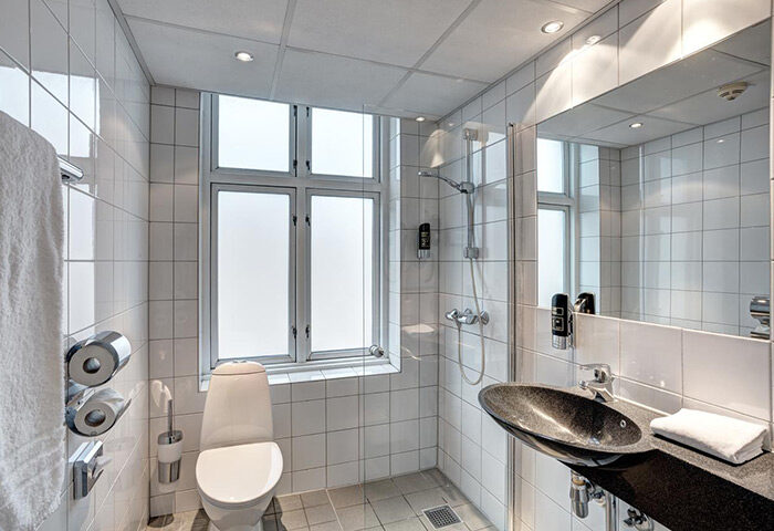 Urban House Copenhagen by MEININGER bathroom. Clean, tiled shower, toilet, and sink in a gay-friendly hostel in Vesterbro gayborhood.