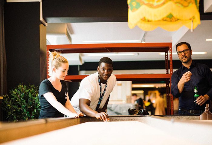 Generator Copenhagen hostel's fun game room near Nyhavn gay bars. People playing shuffleboard, enjoying the best party hostel vibe.