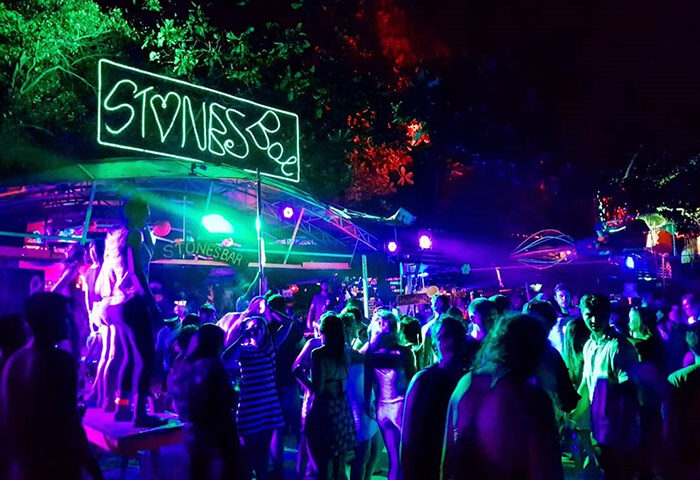 Gay Koh Phi Phi nightlife at Stones Bar. Crowd of people dancing under neon lights. Best gay bars guide update this year. Travel advice.