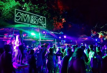 Gay Koh Phi Phi nightlife at Stones Bar. Crowd of people dancing under neon lights. Best gay bars guide update this year. Travel advice.