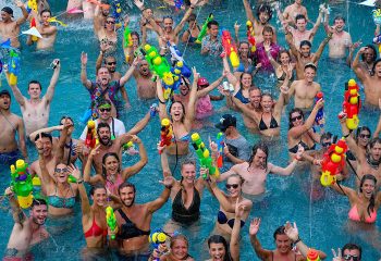Ibiza House pool party. Gay hostel in Koh Phi Phi features partygoers with water guns in a pool. Best pool party for gay men travel.