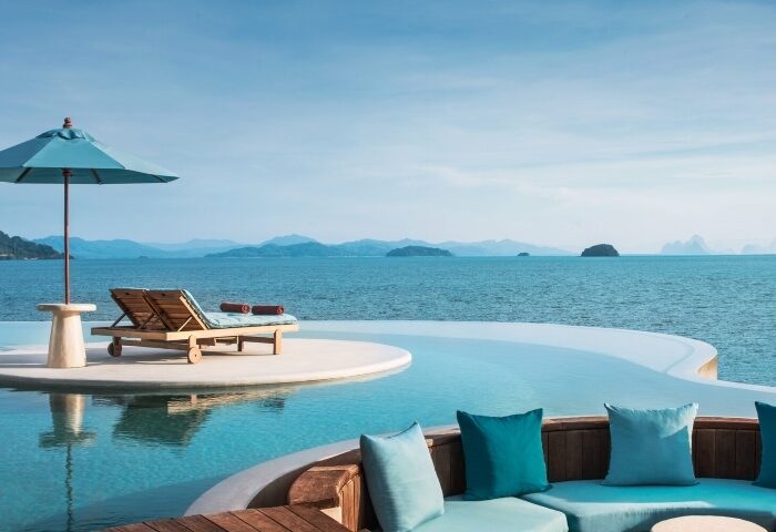 The Naka Island Phuket pool villa view. Best gay hotel Phuket. Lounge chairs and infinity pool overlooking the ocean at luxury resort.