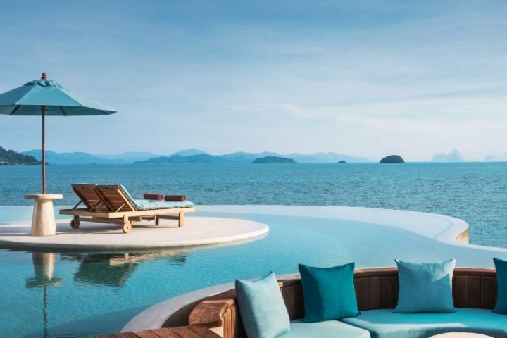 The Naka Island Phuket pool villa view. Best gay hotel Phuket. Lounge chairs and infinity pool overlooking the ocean at luxury resort.