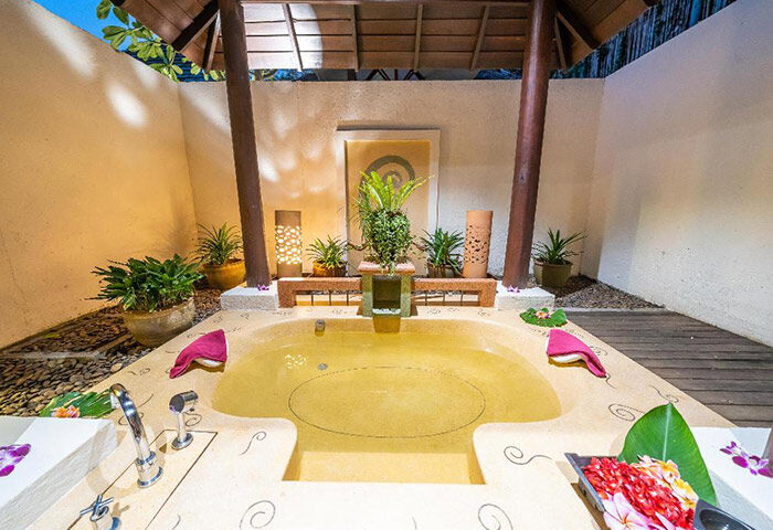 Le Vimarn Cottages & Spa beachfront accommodation, Koh Samet. Outdoor bathtub with flowers, plants, and towels. Gay-friendly travel.