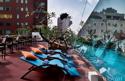 The Myst Dong Khoi's rooftop pool in Ho Chi Minh City. Loungers, tables, and chairs offer relaxation with city views. Gay-friendly hotel.