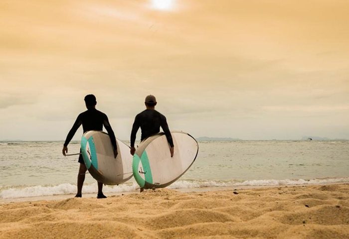 Gay-friendly InterContinental Koh Samui Resort: Two men with surfboards on the beach. A best surfing hotel and gay favorite resort.