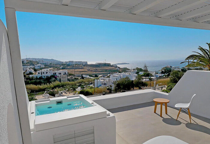Andronikos Hotel Mykonos upscale gay hotel room with private hot tub. Balcony view of the Aegean Sea and Mykonos town. Perfect gay travel destination.