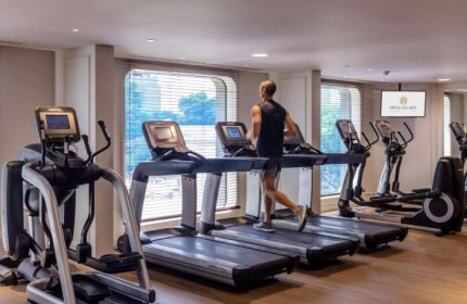 Hotel Des Arts Saigon-MGallery Collection gym. Man running on a treadmill. Best wellness hotel in Ho Chi Minh for gay travelers.